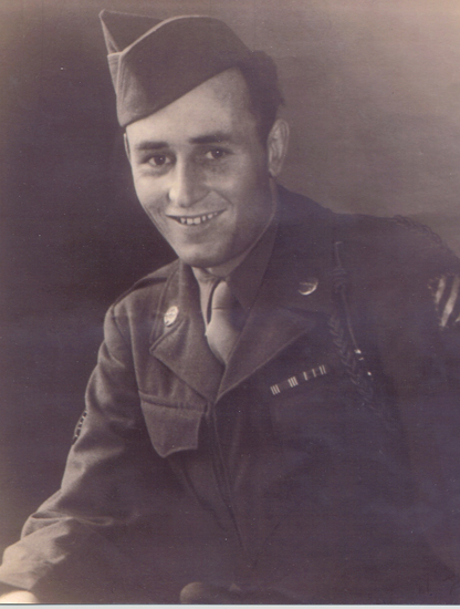 A black and white photograph of an older man in military uniform, looking at the camera with a happy expression.