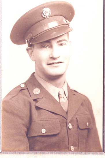 A man in military uniform posing for a portrait. He is wearing a medal. The background is plain.
