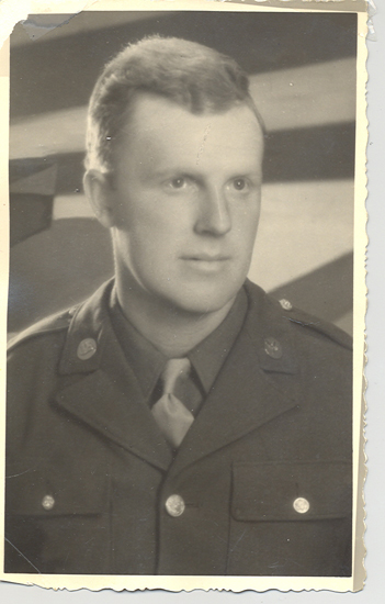 An old black-and-white photo of a man in military uniform.