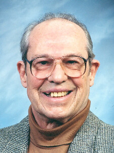 Older man wearing glasses in a formal color portrait.