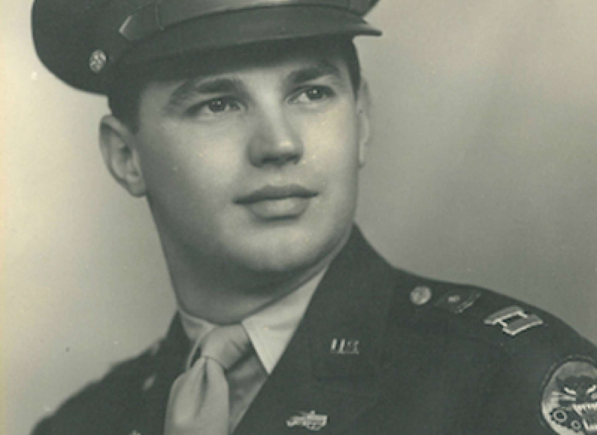 Young serviceman wearing a military uniform and peaked cap.
