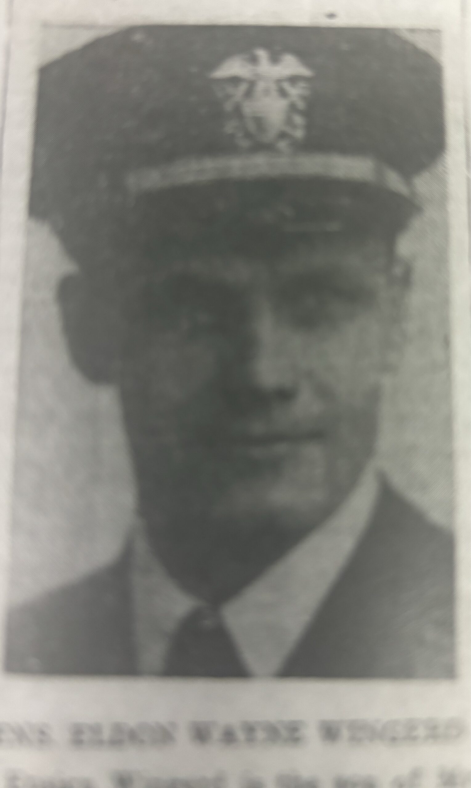 Serviceman wearing a military uniform and cap in a faded portrait.