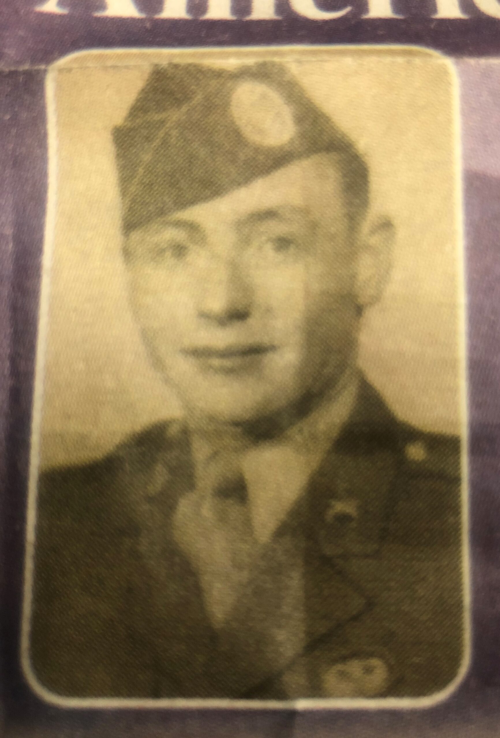 Earl Mills wearing a military uniform and garrison cap in a faded portrait.