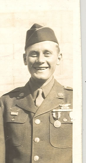 Smiling serviceman wearing a military uniform and garrison cap.