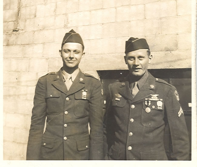 Two servicemen standing together in decorated U.S. Army uniforms.