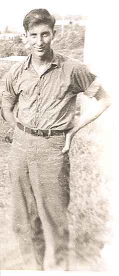 Serviceman standing outdoors in a light-colored military uniform.