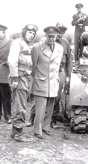 Several men standing near military vehicles, including Dwight D. Eisenhower. The men are all in military uniforms.