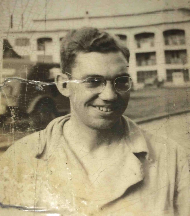 Ernest Warren Shannon wearing glasses while standing beside a military vehicle.
