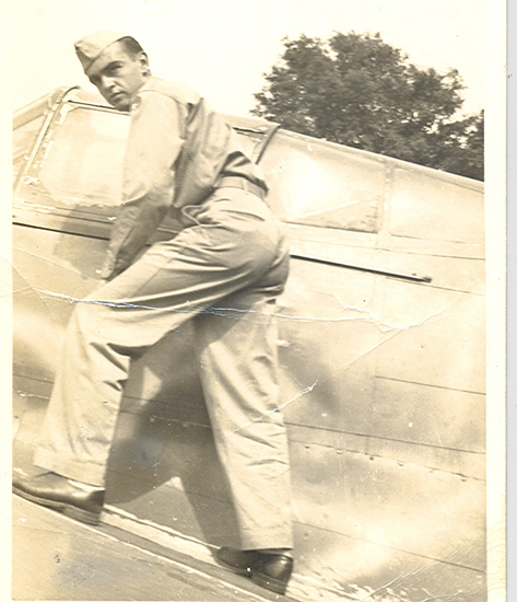 Serviceman climbing the side of an aircraft.