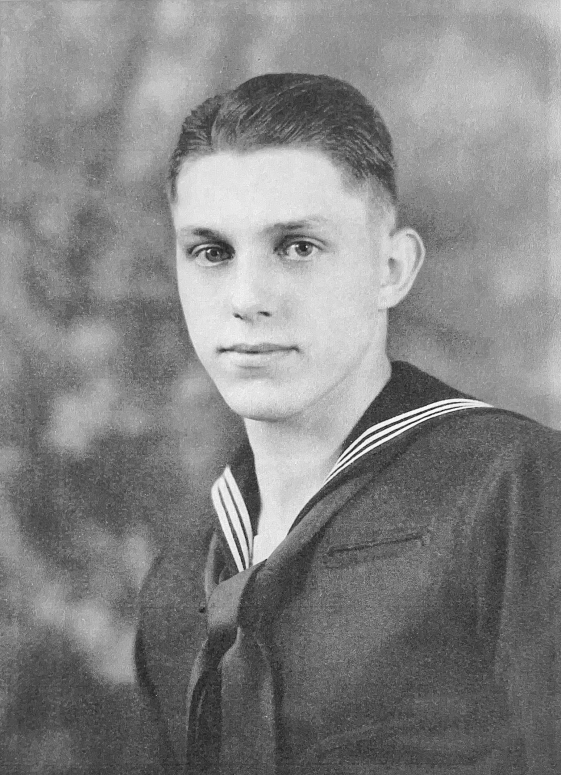 A man in navy uniform with short hair.