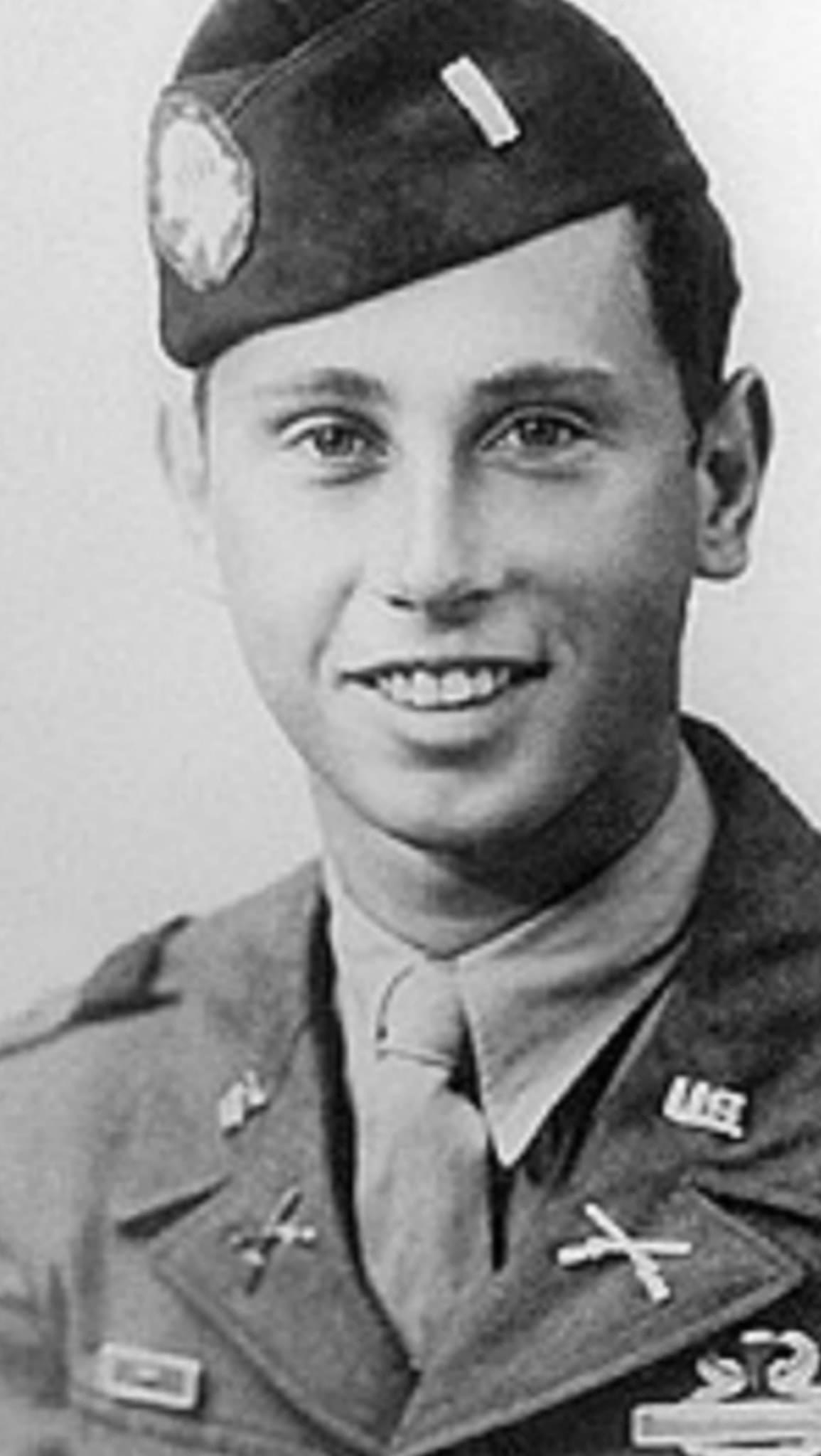 Smiling young serviceman shown in a close-up portrait.