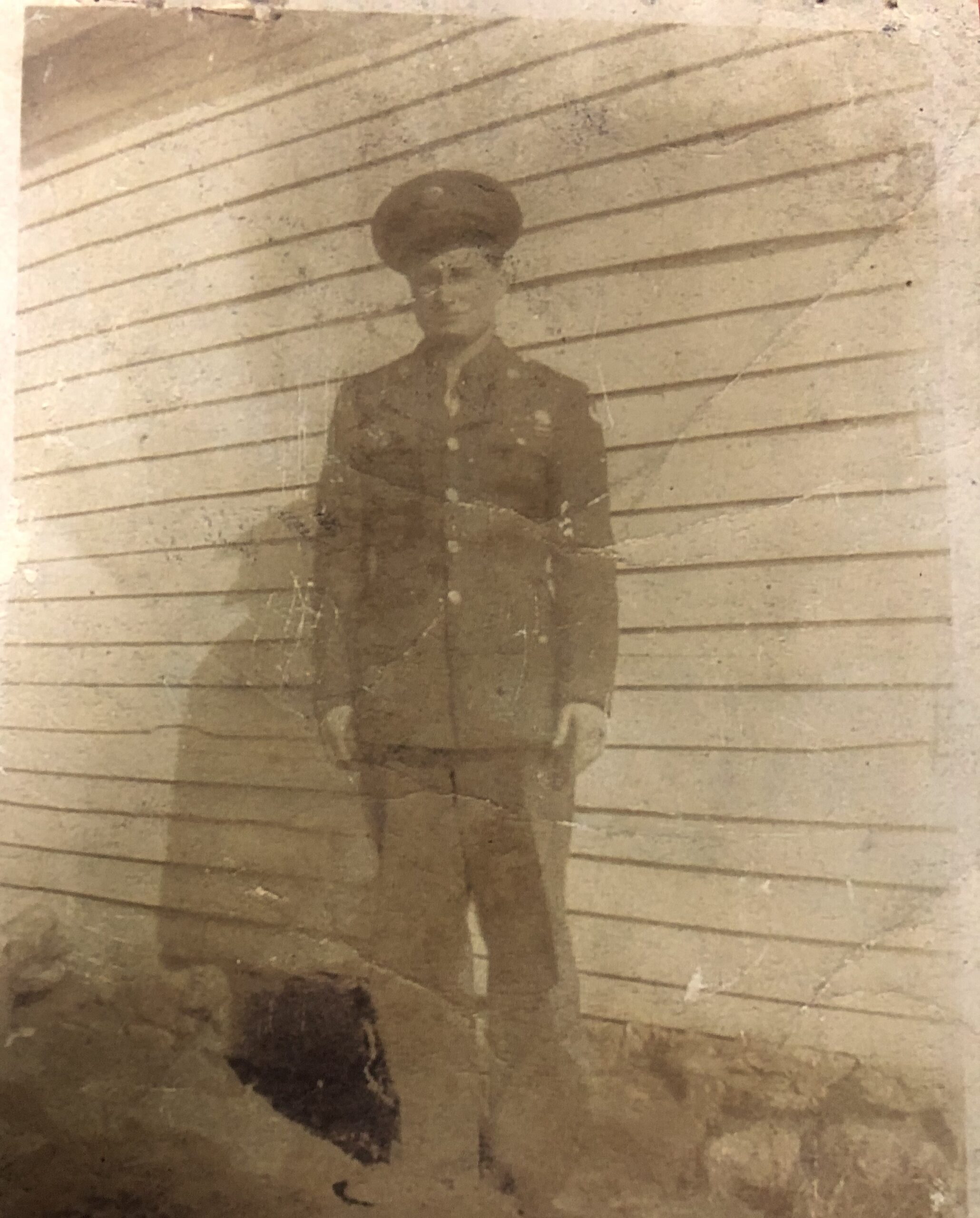 Serviceman standing outside a building in a military uniform.