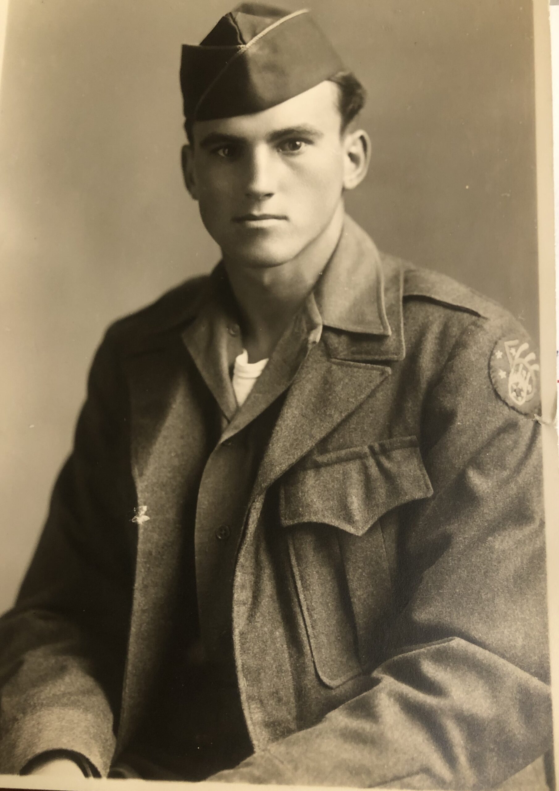 Serviceman seated in a military field uniform.
