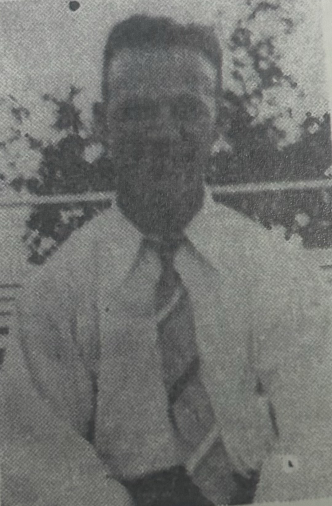 Serviceman shown in a dark, faded outdoor portrait.