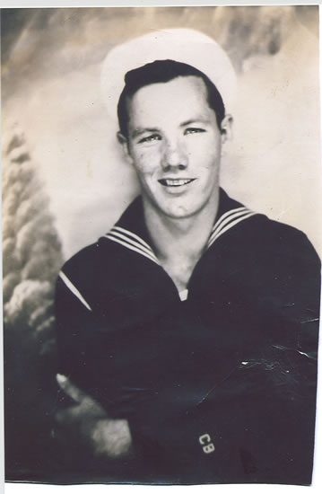 Smiling sailor wearing a dark U.S. Navy uniform.