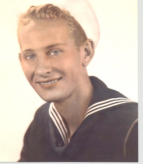 Smiling young sailor wearing a dark U.S. Navy uniform.