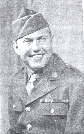 Smiling serviceman wearing a military uniform and garrison cap.