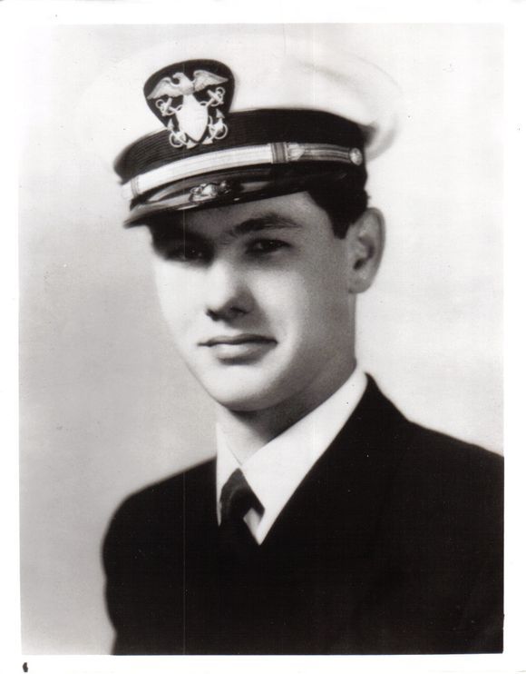 Naval officer wearing a dark dress uniform and peaked cap.