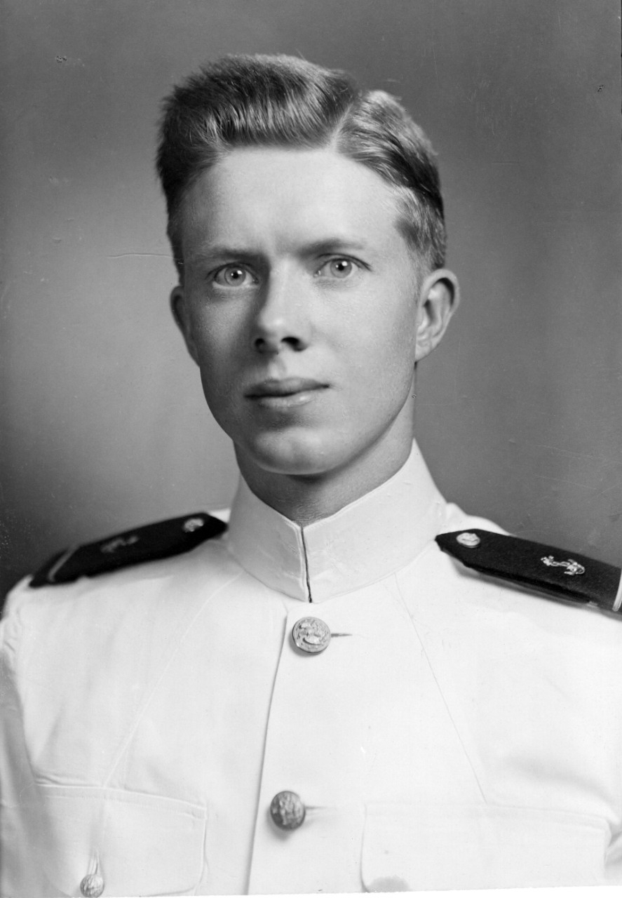 Young naval officer wearing a white dress uniform.