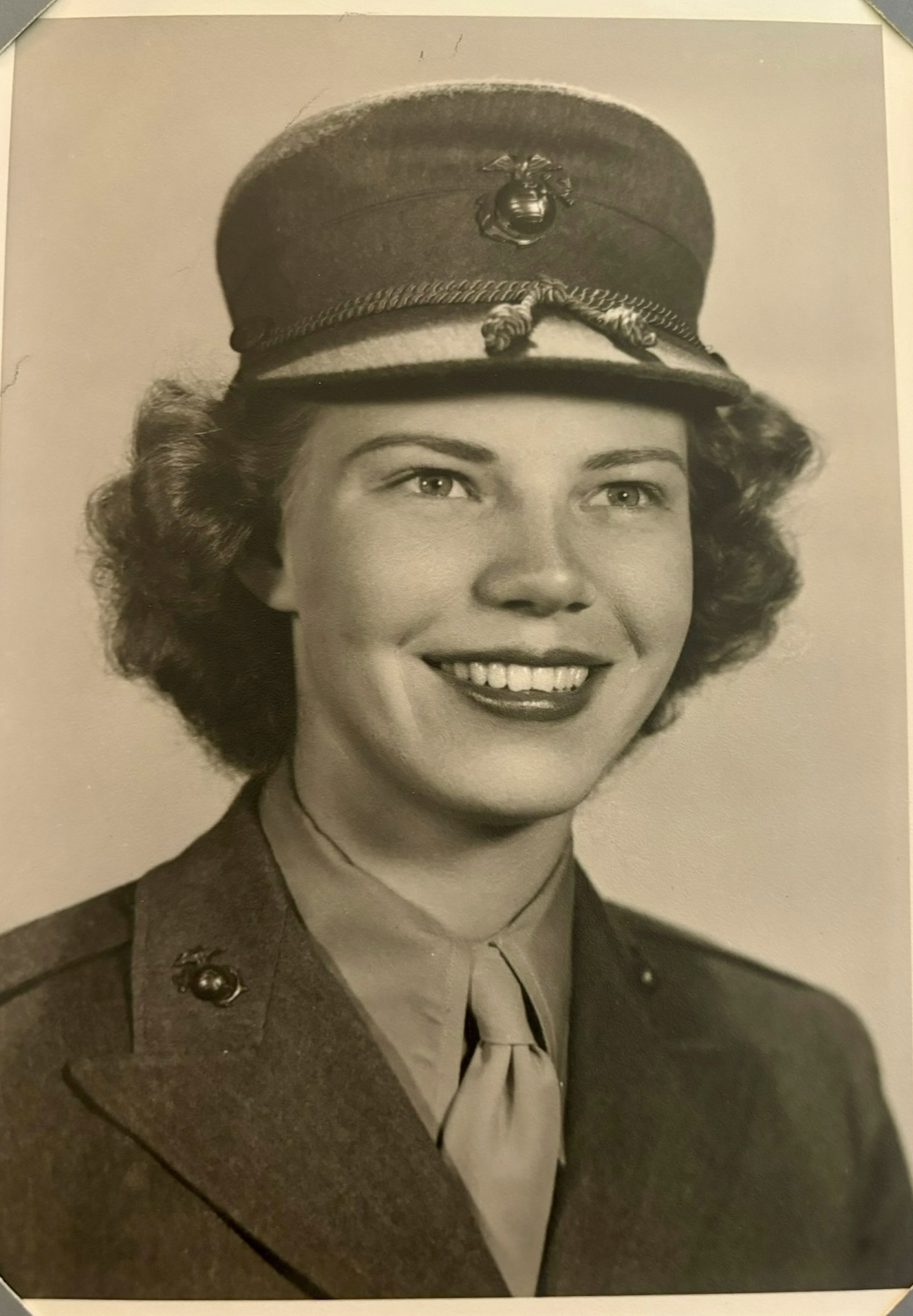 Smiling woman wearing a military uniform and peaked cap.