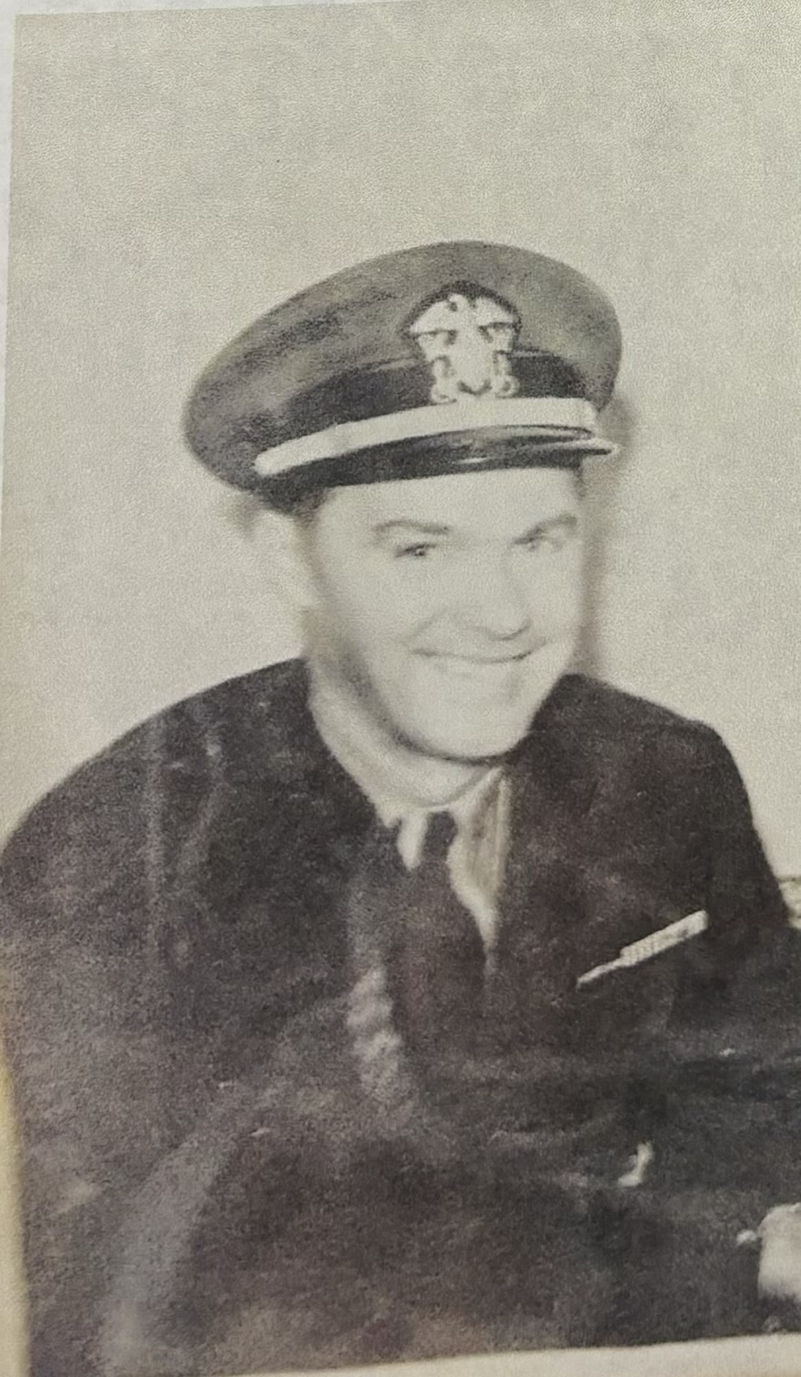Serviceman wearing a U.S. Navy uniform and peaked cap.