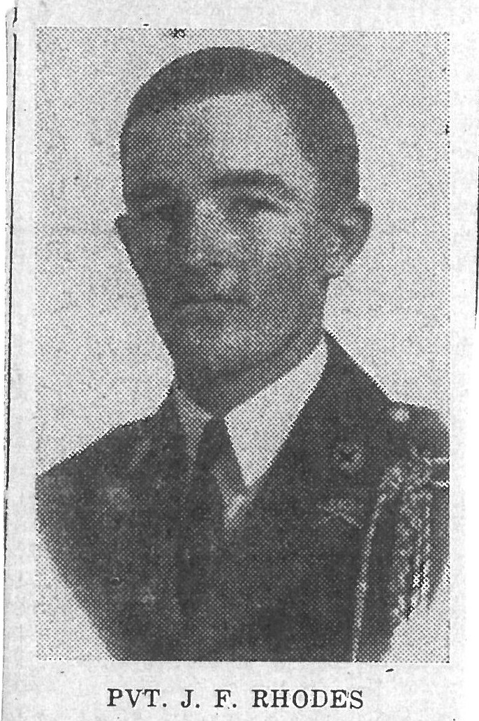 PVT. J. F. Rhodes wearing a suit and tie in a grainy portrait.