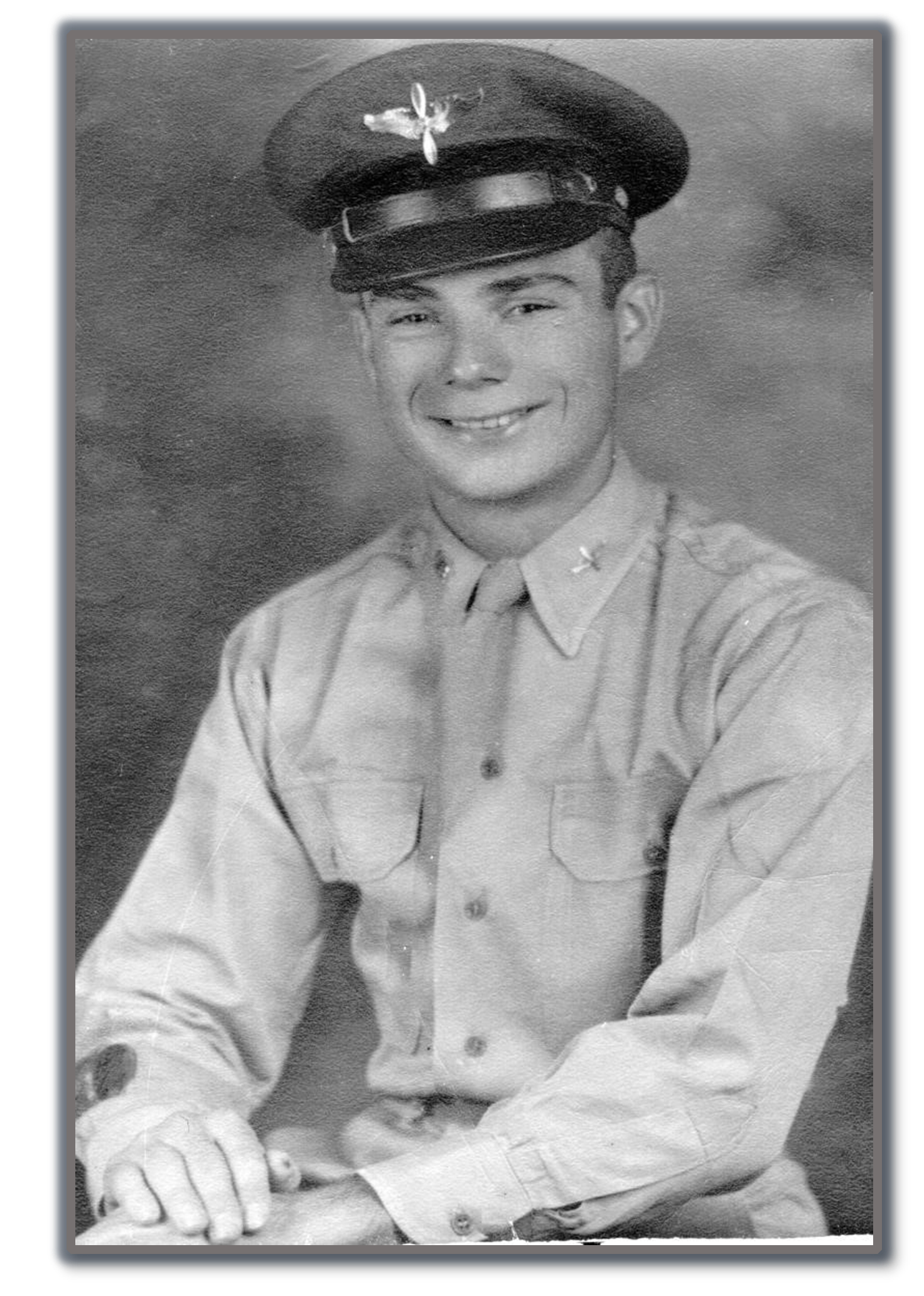 Smiling young serviceman wearing a military uniform and peaked cap.