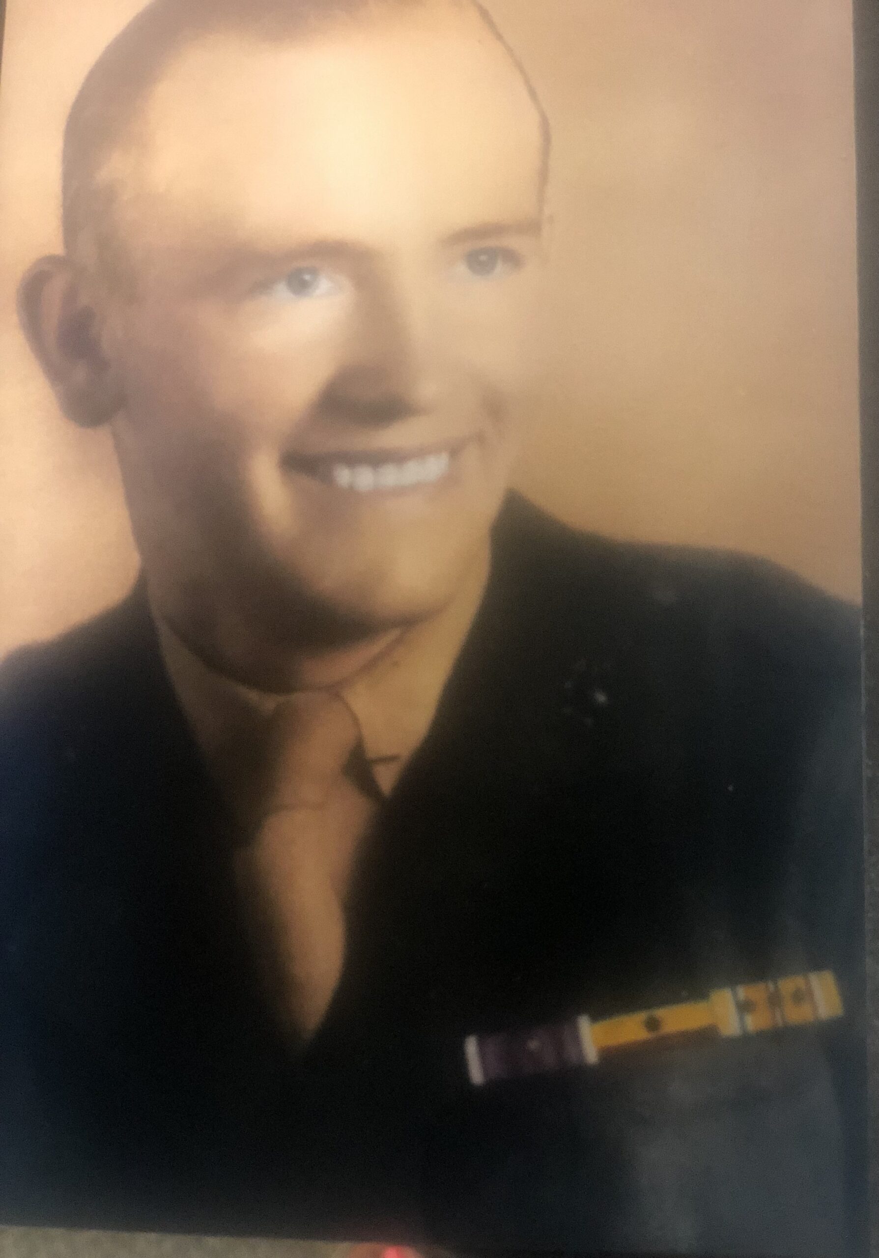 Smiling John Helus wearing a dark military uniform.