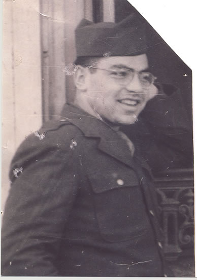 Smiling serviceman wearing glasses and a military uniform.