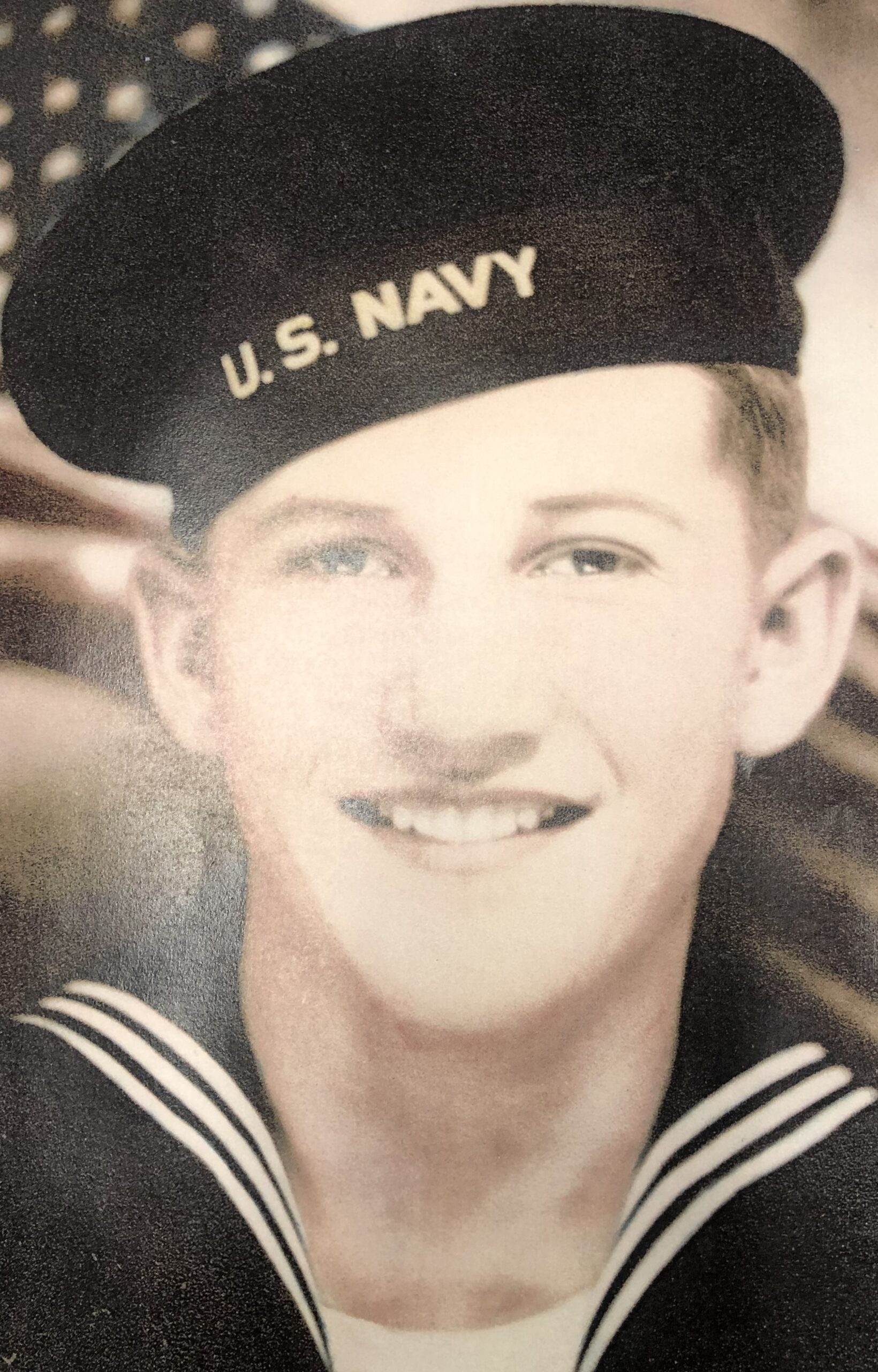 Smiling sailor wearing a U.S. Navy uniform and cap.