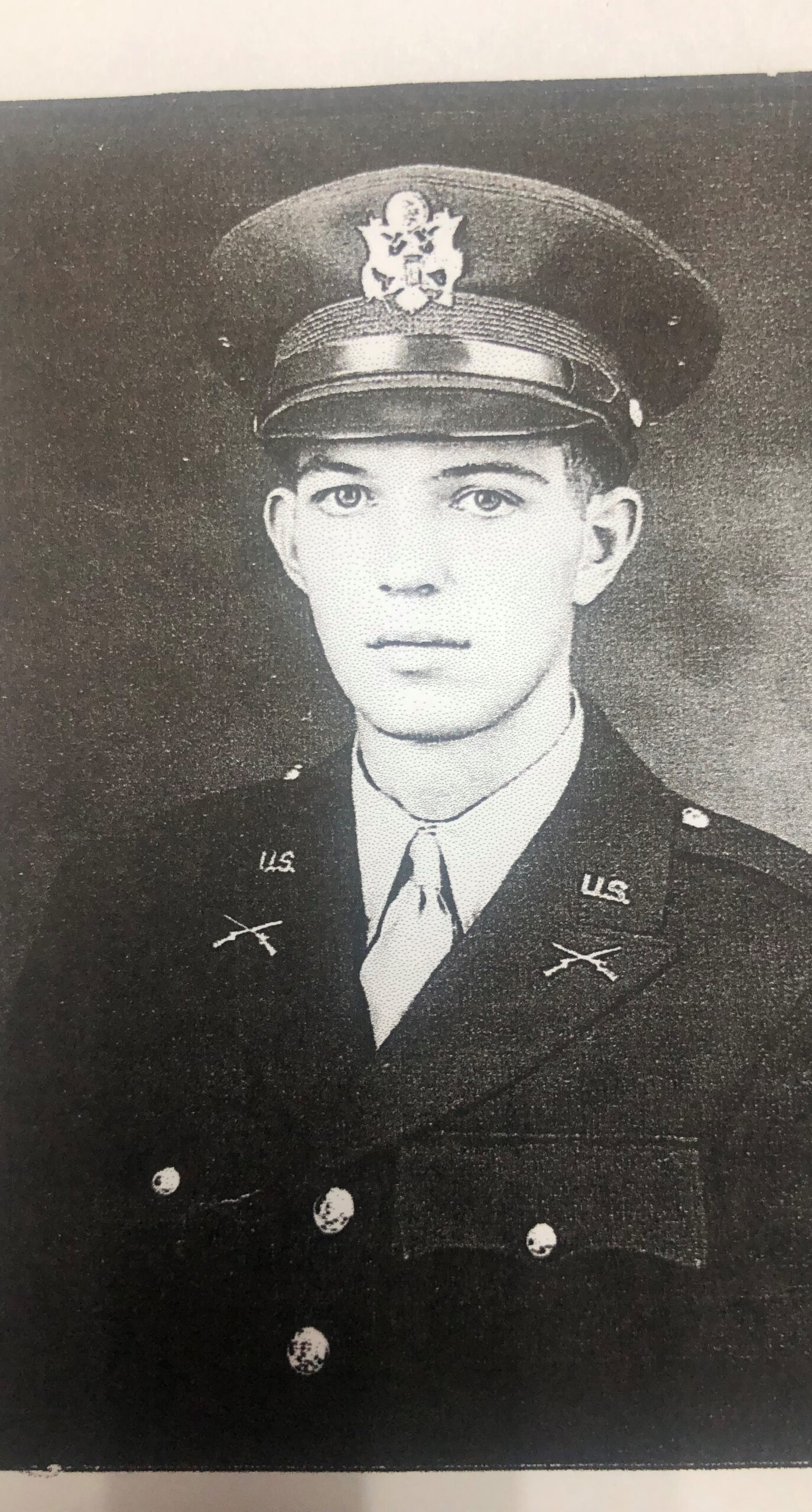 Young military officer wearing a dress uniform and peaked cap.