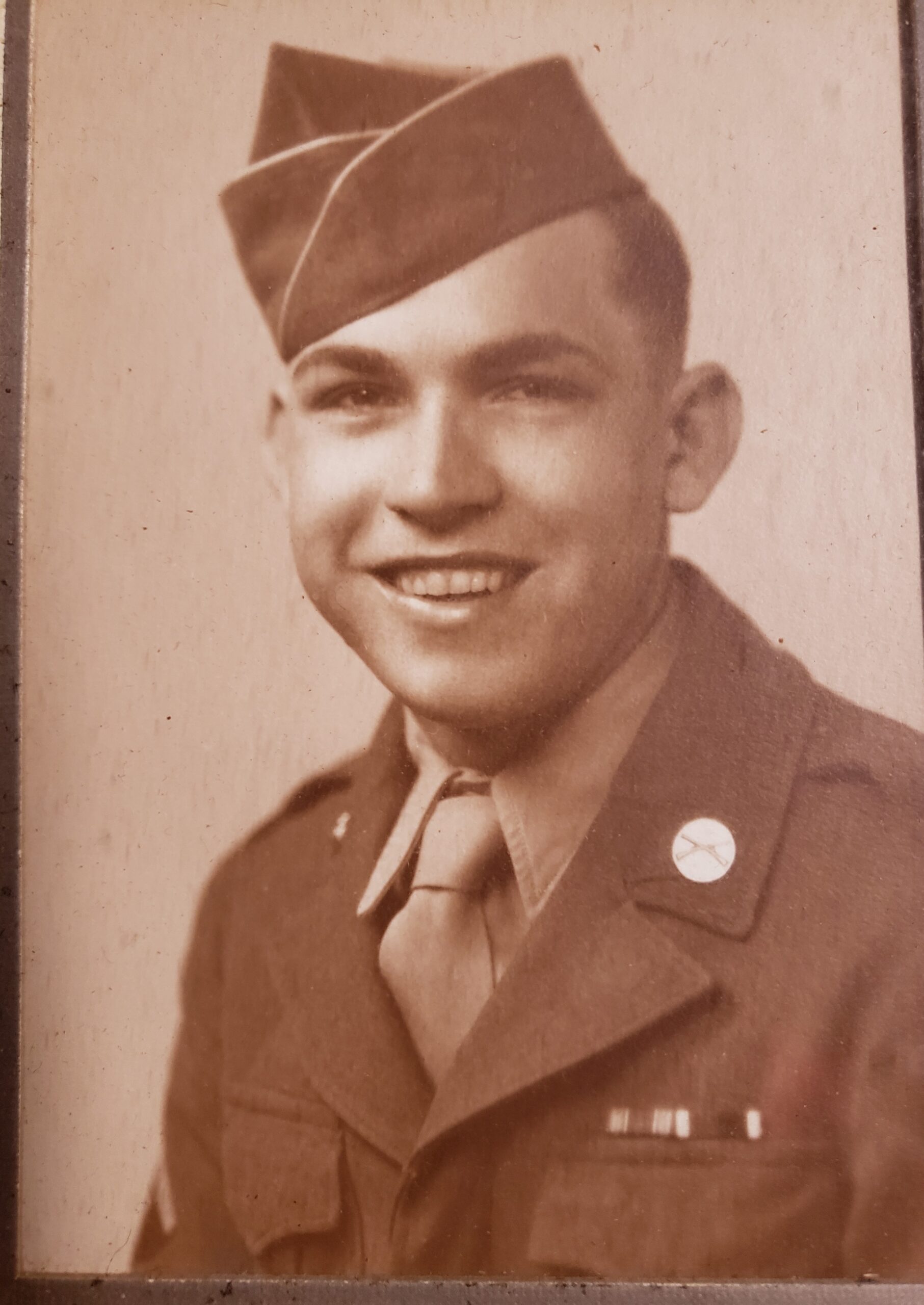 Smiling Leonard Prellwitz wearing a military uniform and garrison cap.