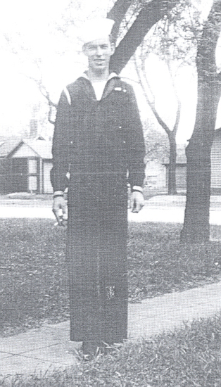 Serviceman standing outdoors in a dark military uniform.