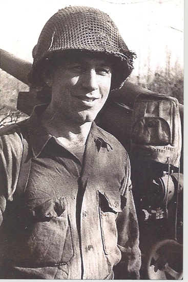 Smiling soldier wearing a helmet and field uniform.
