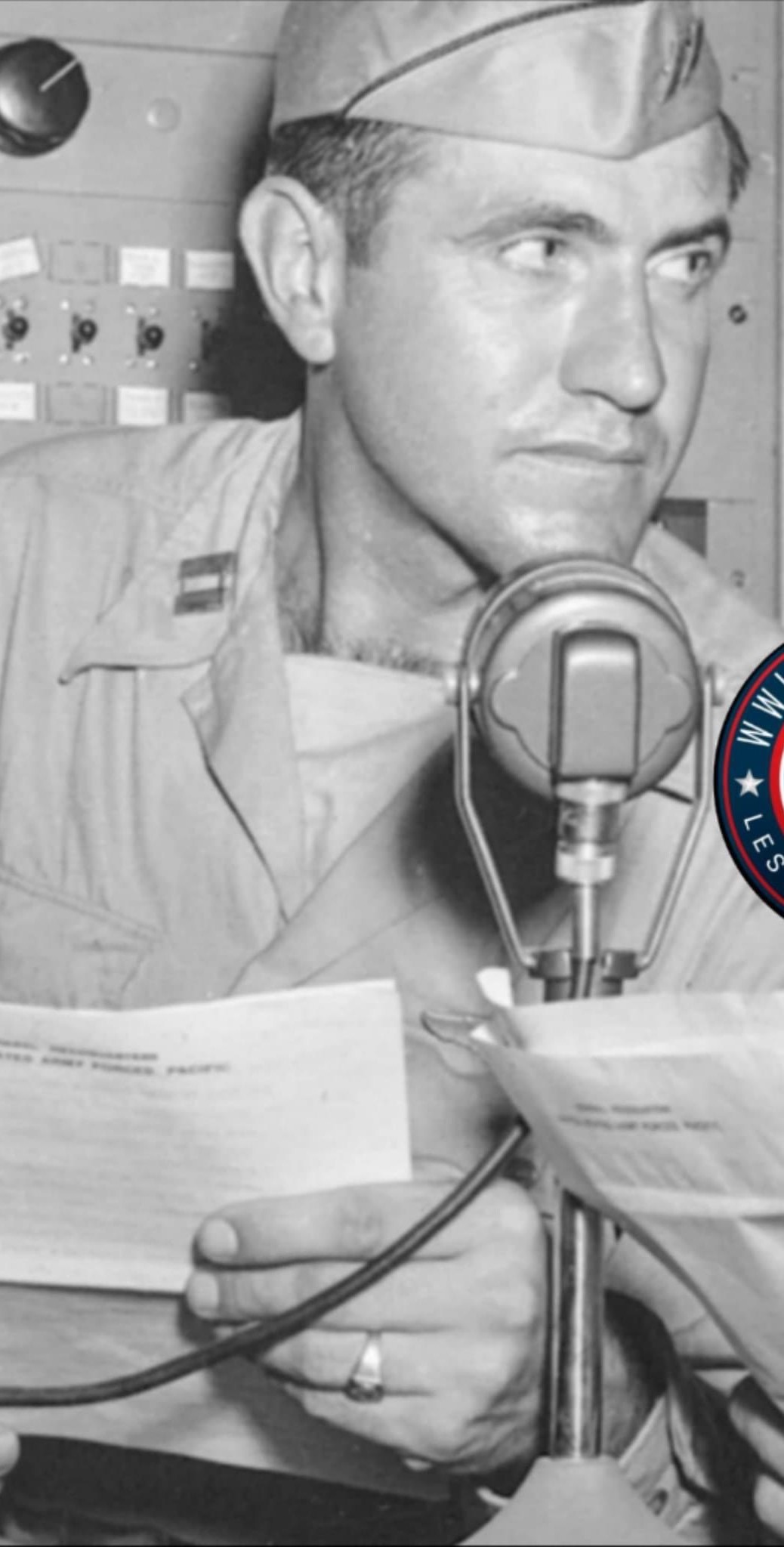 Louis Zamperini wearing a military shirt beside a microphone.