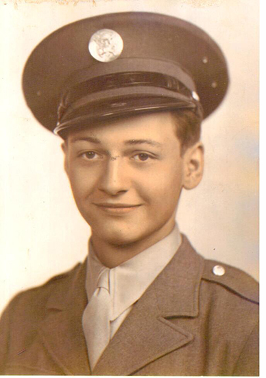 Smiling serviceman wearing a military uniform and peaked cap.