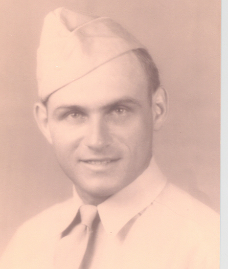 Serviceman wearing a military uniform and garrison cap.