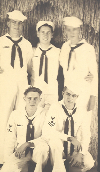Five sailors posing together in naval uniforms.