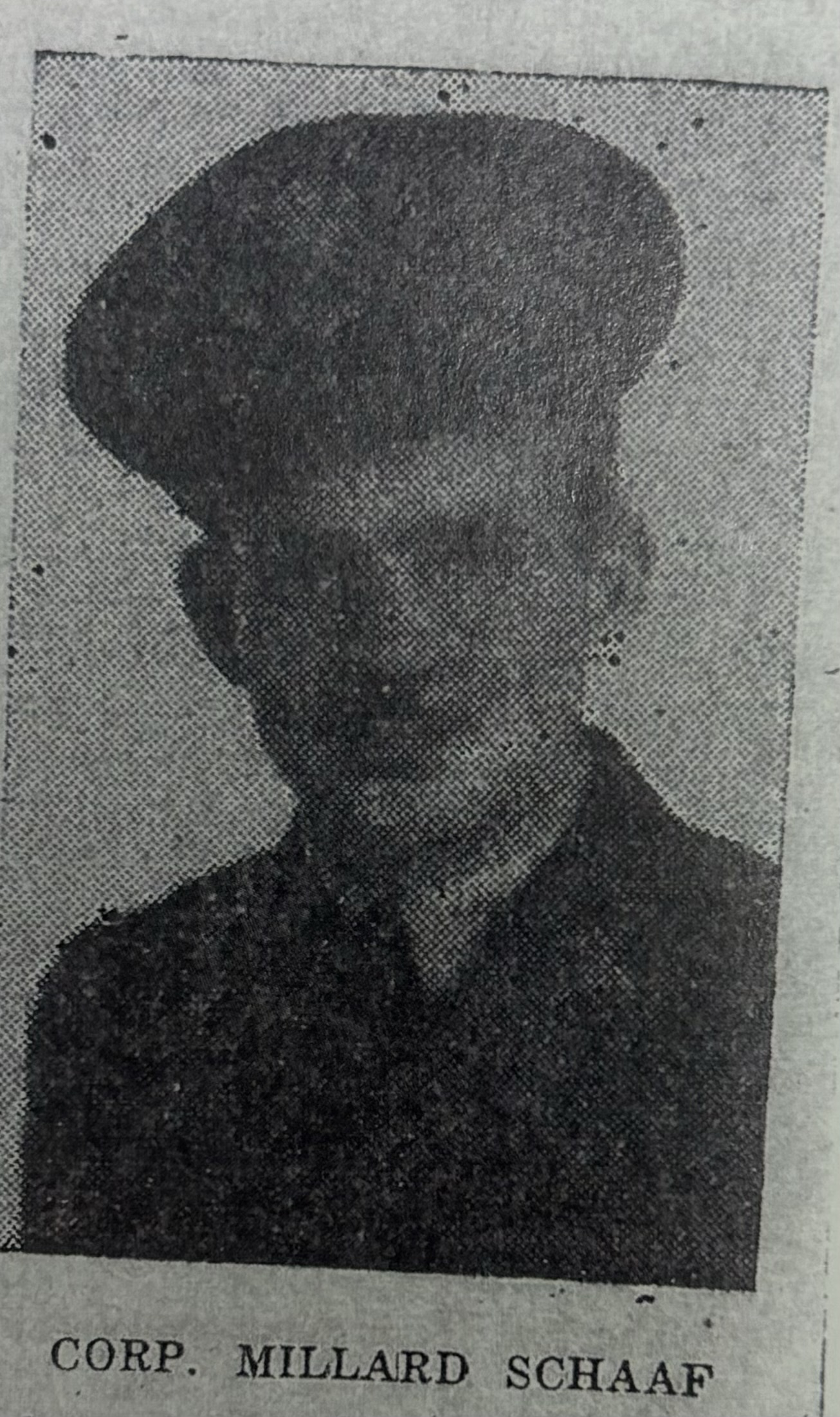 Serviceman wearing a military cap in a dark, grainy portrait.