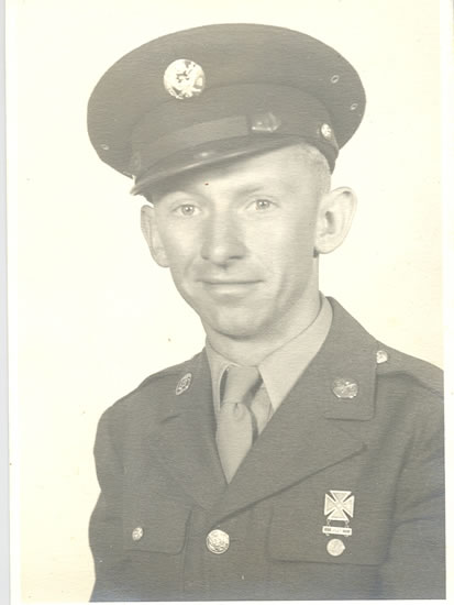 Serviceman wearing a U.S. Army uniform and peaked cap.