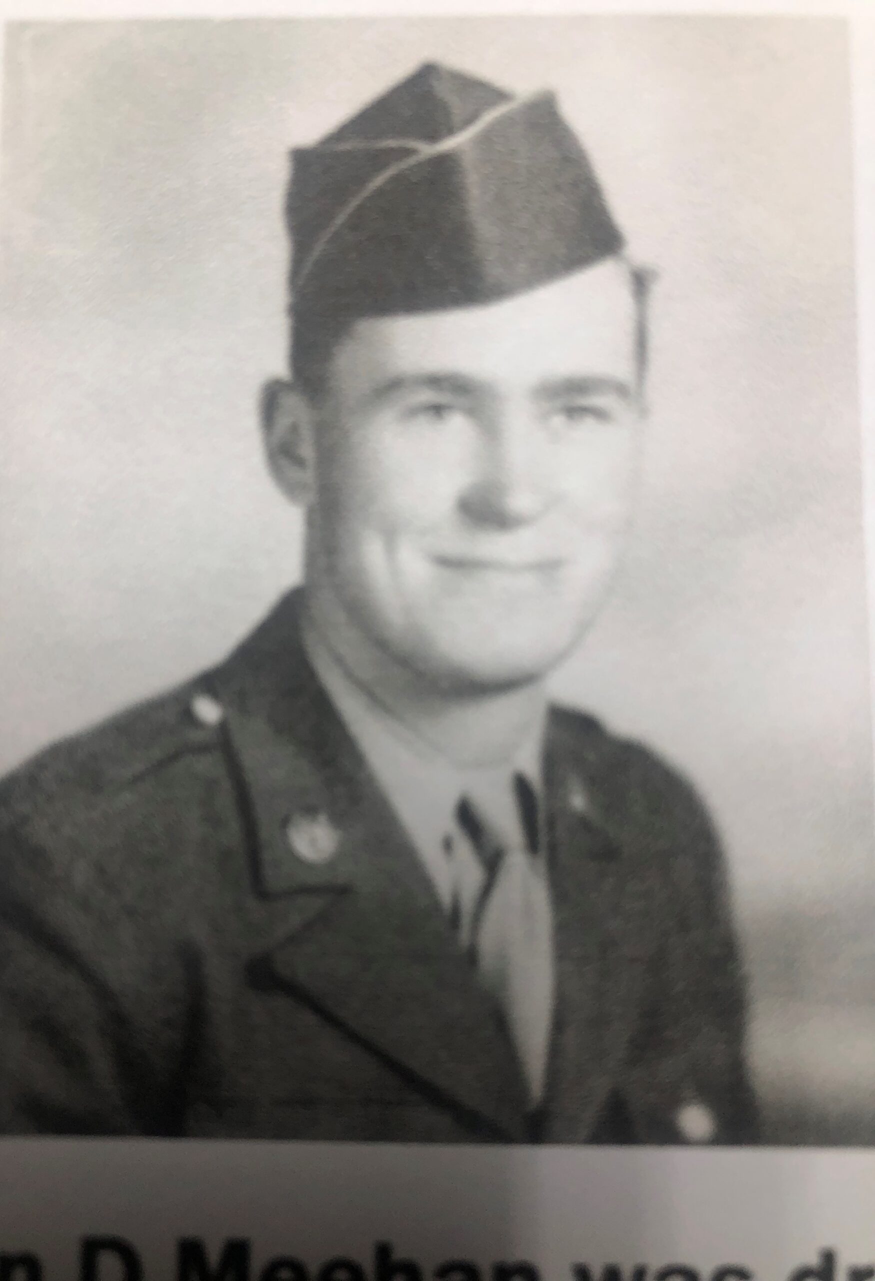 Smiling serviceman wearing a military uniform in a formal portrait.