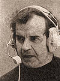 Man wearing headphones while operating communications equipment.