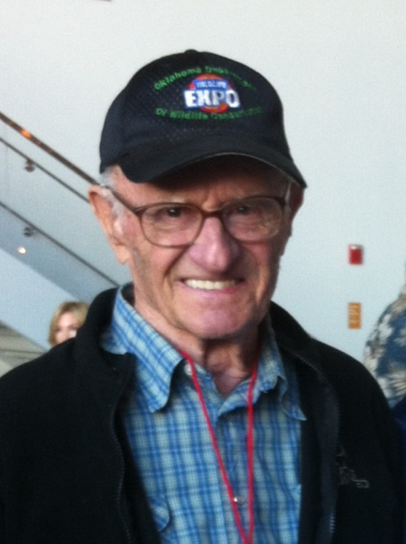 Older veteran wearing glasses and a baseball cap.