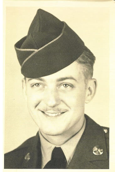 Smiling serviceman wearing a military uniform and garrison cap.