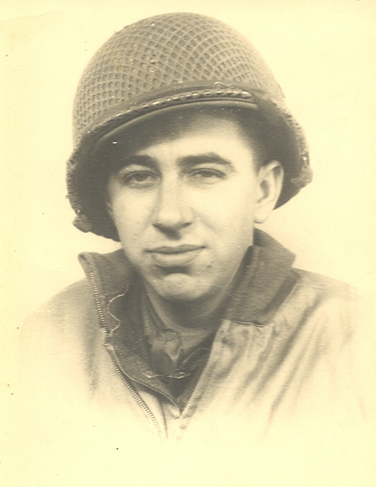 Serviceman wearing a military helmet and field uniform.