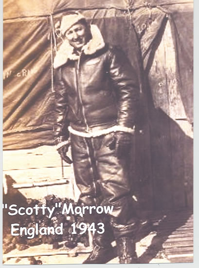 Serviceman standing in military flight gear beside an aircraft.