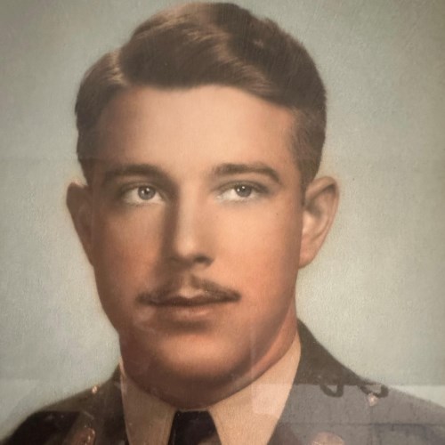 Young serviceman with a mustache shown in a colorized portrait.