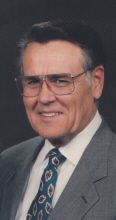 Older man wearing glasses in a formal color portrait.