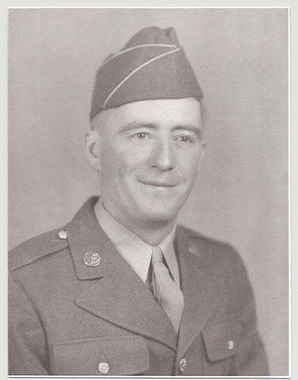 An elderly military man in uniform stands confidently with a soft smile.