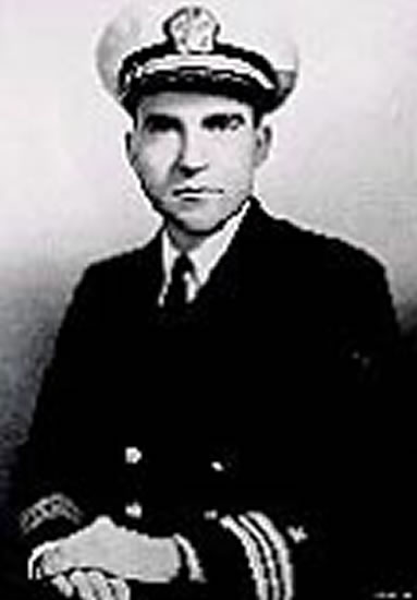 Young man wearing a dark suit and tie in a formal portrait.